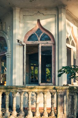Old arch window in abandoned house or mansion with terrace. Vertical orientation