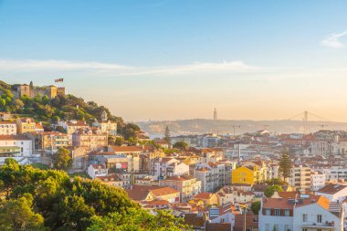 Tagus Nehri 'ndeki Lizbon' un ortaçağ binaları ve şatosuyla günbatımı manzarası. Lisboa, Portekiz silueti. Seyahat hedefi