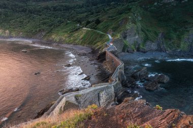 Güneş doğarken San Juan de Gaztelugatxe Adası 'ndaki taş köprüdeki merdivenler. Bask kıyı şeridi. Seyahat hedefi