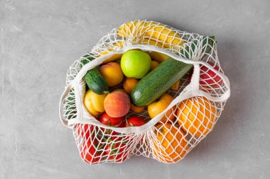 Marketten alınmış sebzelerin içinde sağlıklı organik meyveler bulunan ağ alışveriş torbası. Üst Manzara. Vejetaryen ya da vejetaryen ürünleri. Sürdürülebilir yaşam tarzı kavramı