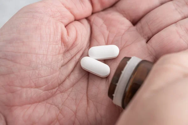 Fájdalomcsillapító Fehér Tablettákat Szed Férfi Kézre Tablettákat Tölt Gyógyszeres Üvegből — Stock Fotó