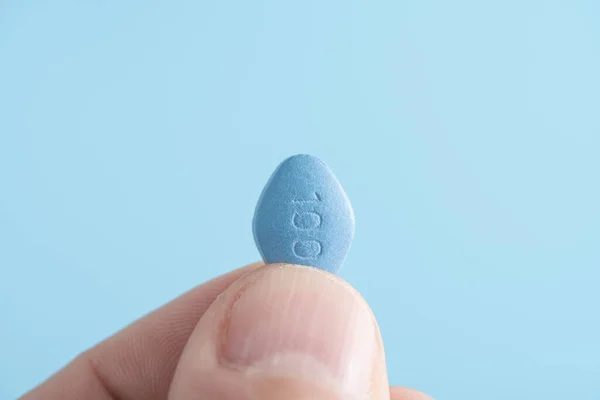 Man Houdt Blauwe Pil Viagra Vingers Blauwe Achtergrond Geneeskunde Concept — Stockfoto