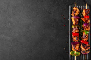Biber ve soğan dilimli tavuk şişleri. Şiş kebap, siyah arka planda ızgara et. Üst Manzara. Lezzetli yemek.
