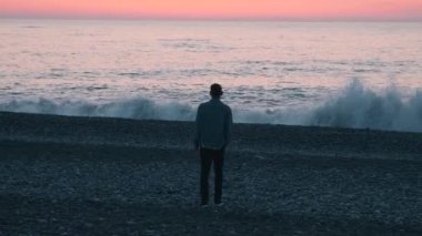 Gün batımında deniz kıyısında yürüyen yalnız bir adam. Okyanusun kıyısında zihinsel sorunları olan bir erkek. Yalnızlık, depresyon, melankoli, stres konsepti