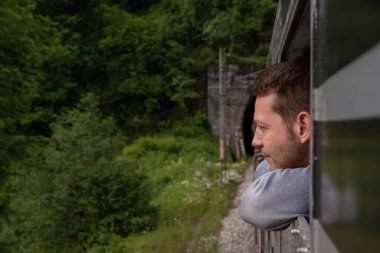 Balkanlar 'a demiryolu ile seyahat eden çekici bir adam. Tren tünele girip düşünürken yakışıklı genç bir erkek trenin camından dışarı bakıyor. Düşünceli, düşünceli adam.