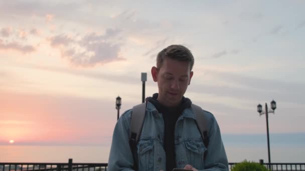 Молодой Красивый Мужчина Путешественник Используя Смартфон Бронирования Размещения Открытом Воздухе — стоковое видео
