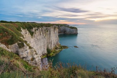 Etretat, Normandiya, Fransa uçurumunun gün doğumu manzarası. Beyaz kayalardan ve Manche kanalından oluşan kıyı manzarası. Popüler seyahat hedefi.