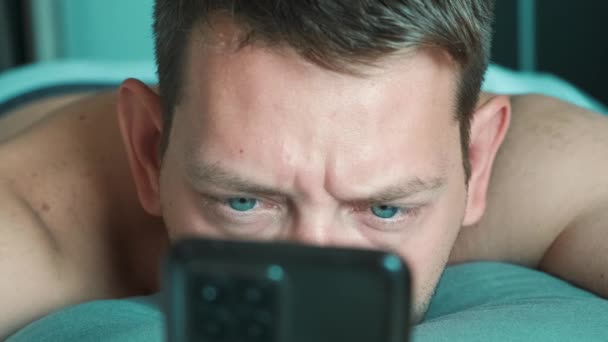 Schöner Mann Blättert Morgens Mit Dem Smartphone Bett Surft Internet — Stockvideo