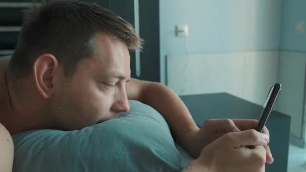 Schöner Mann Der Morgens Mit Dem Handy Bett Surft Soziale — Stockvideo