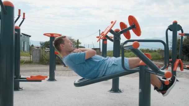 Ενεργός Άνθρωπος Άσκηση Στο Υπαίθριο Γυμναστήριο Νεαρό Αρσενικό Κάνει Ασκήσεις — Αρχείο Βίντεο