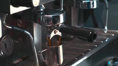 Barista kahve makinesiyle kahve yapıyor. Garson kafedeki kahve makinesinden sıcak espresso yapıyor..