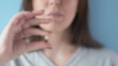 Gastrit, mide ülseri, mide yanması ilacı kapsülü ya da mavi arka planda hap olan bir kadın. İlaç, sağlık, eczane ve tedavi konsepti almak. Seçici odak