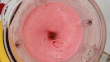 Çilekli ve muzlu milkshake karıştırılmış. Üst Manzara. Ağır çekim. Sağlıklı içki konsepti.