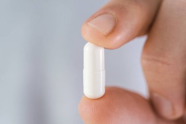 Erkek elinde kolajenle beyaz kapsülü tut. Besin takviyesi, ilaç, eklemler için ilaç, cilt bakımı, artrit önleme. 