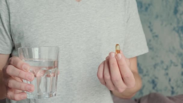 男人喝欧米加3胶囊 维生素D和一杯水 鱼油营养补充剂 保健支助和治疗概念 — 图库视频影像