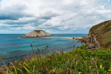 Playa de Covachos plajı Santander, Cantabria, Kuzey İspanya kayalık adası ve kumlu tükürüğüyle. Tatillerde popüler seyahat