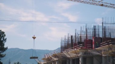 Crane inşaat malzemelerini bir inşaat alanının çatısına kaldırıyor. Yeni konut inşaat endüstrisi. Endüstriyel kavram.