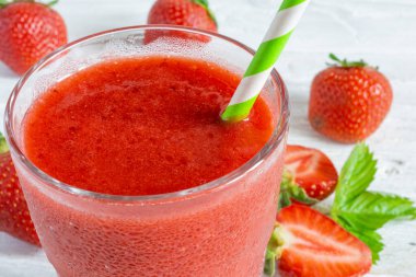 Çilekli smoothie 'yi taze böğürtlen ve beyaz ahşap arka planda samanla bardağa doldur. Soğuk yaz içeceği kokteyli. Sağlıklı diyet içeceği.