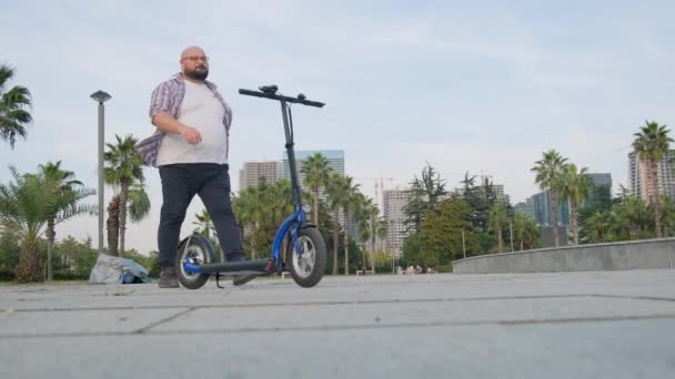 Hombre Con Sobrepeso Montando Scooter Eléctrico Ciudad Hombre Conduciendo Scooter — Vídeos de Stock