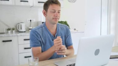 Karpal tünel sendromu ve bilek eklemi iltihabından muzdarip çok çalışan genç iş adamları uzun bir gün boyunca evde dizüstü bilgisayarla çalıştılar. Erkek serbest çalışanın sağlık sorunu var. Ofis sendromu