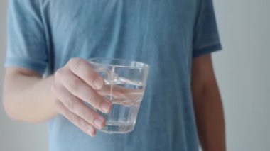 Titreme ve Parkinson hastalığından muzdarip el sıkışarak bardak tutan adam. Parkinson sendromlu bir erkek titreyen camlardan su içmeye çalışır. Nörolojik hastalık. Yavaş çekim