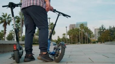 Şehirde elektrikli scooter kullanan kilolu bir adam. Erkek, açık havada e-scooter kullanıyor. Elektrik ve ekolojik taşıma. Çevre dostu ulaşım. Sürdürülebilir yaşam tarzı kavramı.