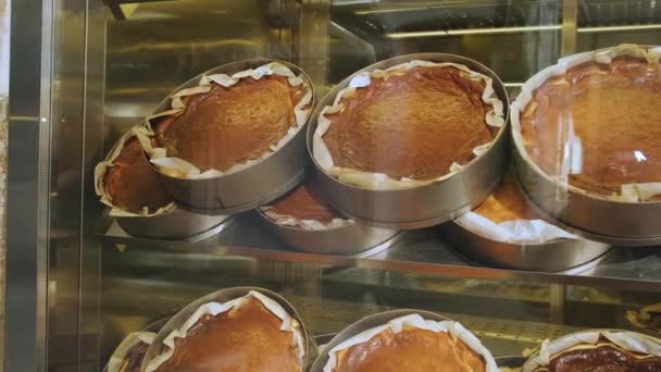バスクはペストリーショップのショーケースでチーズケーキを焼きました カフェで美味しいサンセバスチャンケーキ — ストック動画