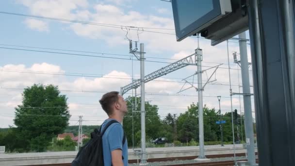 Homem Mochileiro Estação Trem Olhando Para Exibição Horário Trem Homem — Vídeo de Stock
