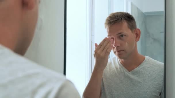 화장실에 얼굴에 크림을 거울을 잘생긴 남자의 일상적인 — 비디오