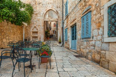 Açık hava restoranındaki eski ortaçağ kasabası Hvar 'ın eski rahat sokağında, dışarıda kafe masaları ve sandalyeler. Hırvatistan' ın Dalmaçya kentinde kimse yok. Yaz tatillerinde popüler seyahatler ve turistik yerler.