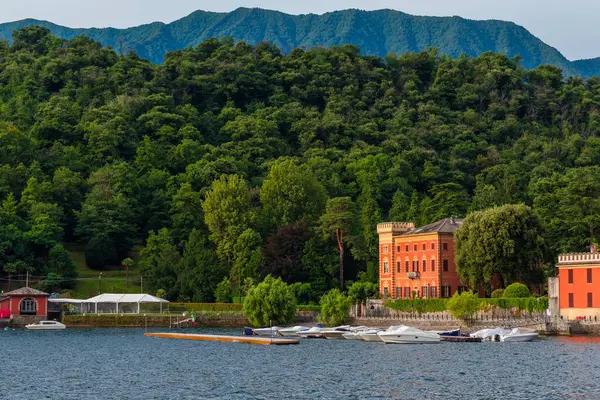 Como lake with colorful Villa in the forest and boats in Lenno comune, Lombardy, Italy. Italian landscape. Popular travel and tourist destination on summer vacations.