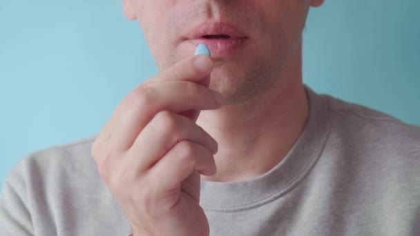 Homem Toma Pílula Azul Nos Dedos Fundo Azul Conceito Medicina — Vídeo de Stock