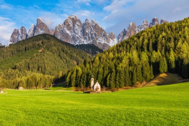 Santa Maddalena köyünde karla kaplı Geisler tepelerine karşı San Giovanni kilisesi, Dolomites dağlarında Val Di Funes, Trentino Alto Adige, İtalya. İtalyan Alpleri