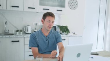 Başarılı genç adam bilgisayarın bilgisayar ekranına bakıp ellerini kaldırarak zaferini kutluyor. Şaşırmış erkek kazanan şans, başarı ve zaferle mutlu hissediyor. Heyecanlı bir işadamı...