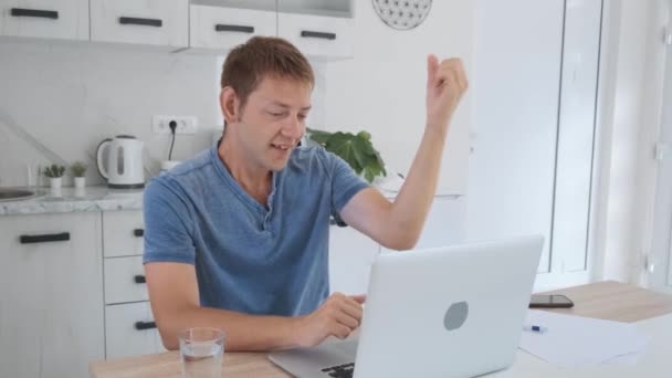 Счастливый Взволнованный Европеец Работающий Над Ноутбуком Поднимающий Руку Отпраздновать Победу — стоковое видео