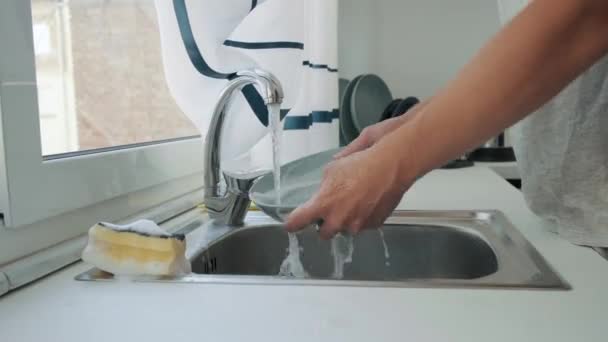 男人在厨房洗碗槽里洗碗 男性的手在家里用海绵和肥皂洗碗 日常家务活 — 图库视频影像