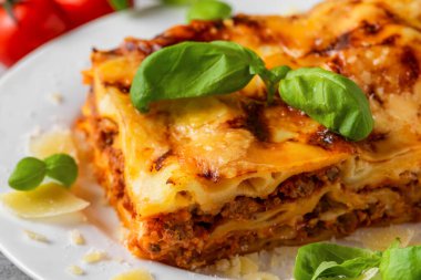 Ev yapımı et lazanyası, taze fesleğenli, parmesan peynirli tabak. İtalyan mutfağı. Akşam yemeği için lezzetli yemekler..