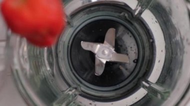 Blender 'da çilekli smoothie pişiriyorum. Blender 'a olgun böğürtlen döküyorum. Ağır çekim. Sağlıklı içki konsepti. Üst görünüm