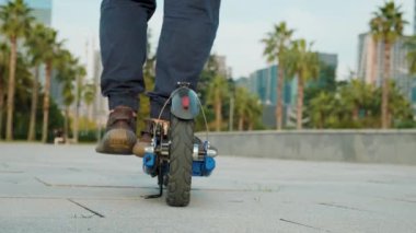 Artı şehirde elektrikli scooter kullanan bir adam. Erkek, açık havada e-scooter kullanıyor. Elektrik ve ekolojik taşıma. Çevre dostu ulaşım. Sürdürülebilir yaşam tarzı kavramı.