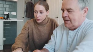 Yaşlı dedeme dizüstü bilgisayarı nasıl kullanacağını öğreterek, evde bilgisayarda nasıl daktilo yazılacağını göstererek. Yaşlılar ve ilgili aile. Yaşlılar ve modern teknoloji kavramı.