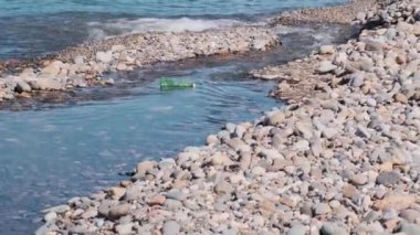 Plastik su kirliliği. Plastik şişe nehirden denize doğru yüzüyor. Yağmacılar ve denizlerdeki plastik atık çevresel kirlilik sorunu. Ekolojik felaket. Dünya Günü konsepti.