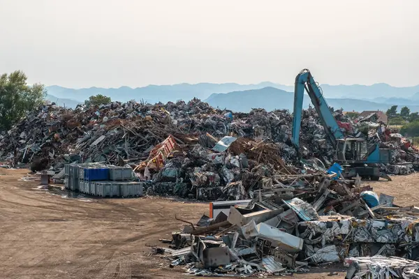 Clow crane picking up scrap metal at recycling center for metal, aluminum, brass, copper, stainless steel in junk yard. Recycling industry. Environment and zero waste concept.