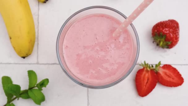Masanın Üzerinde Pipetle Çilekli Muzlu Milkshake Üst Görüntüsü Sağlıklı Içecek — Stok video