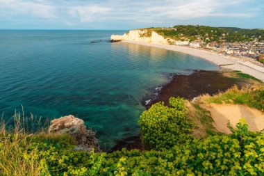 Beyaz tebeşir kayalıkları ve Etretat kasabasında doğal kemerleri olan çakıl taşı plajlarının panoramik manzarası ve Fransa, Normandiya 'da alçak sularda güzel ve ünlü kıyı şeridi. Normandie 'de ünlü Fransız deniz kıyıları