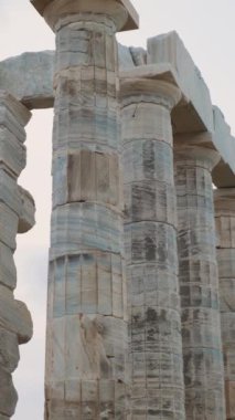 Cape Sounion, Attica, Yunanistan 'daki Poseidon Tapınağı Sütunları. Antik Yunan mimarisi. Yunan deniz tanrısı sütunlu antik tapınağın kalıntıları. Dikey oryantasyon. Popüler seyahat ve