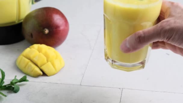 Mão Homem Coloca Vidro Smoothie Manga Amarela Milkshake Com Hortelã — Vídeo de Stock