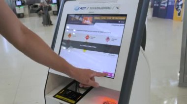 Bangkok, Tayland - 05: 15 2024: Bangkok havaalanı, Tayland 'da otomatik servis kayıt cihazını kullanan kişi. Seyahat uygulaması için terminale giden erkek gezgin.