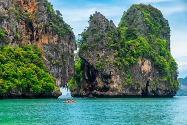 Phra Nang sahilindeki Rocky Adası, Railay Körfezi, Krabi, Tayland. İnsanlar tropik kayalıklar arasında kayak yapıyor. Yaz tatili ve tatil geçmişi.