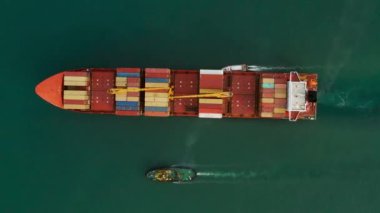 İthalat ve ihracat için konteynır taşıyan kargo gemisinin hava görüntüsü, iş lojistiği ve açık denizde ulaşım. Üst İHA görünümü. Nakliye.