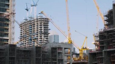 Dubai City, BAE 'de birden fazla vinç, yapı iskelesi ve yüksek binaları olan inşaat alanı. İnşaat endüstrisi ve modern mimari.
